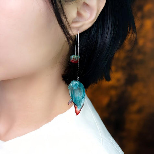 Emo leather drop earrings product shot showing pair, teal-to-crimson gradient and irregular torn edges on neutral background