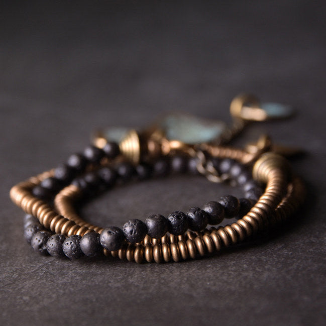 Lava stone brass bracelet worn outdoors with floral print dress