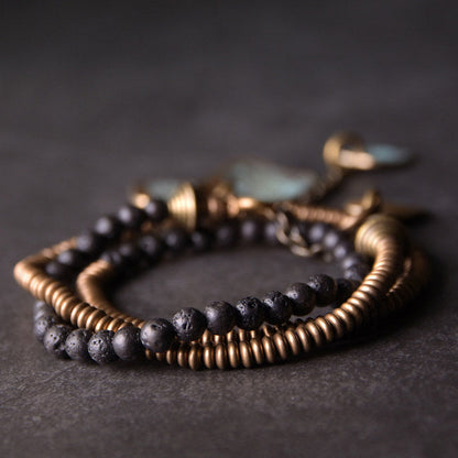 Lava stone brass bracelet worn outdoors with floral print dress