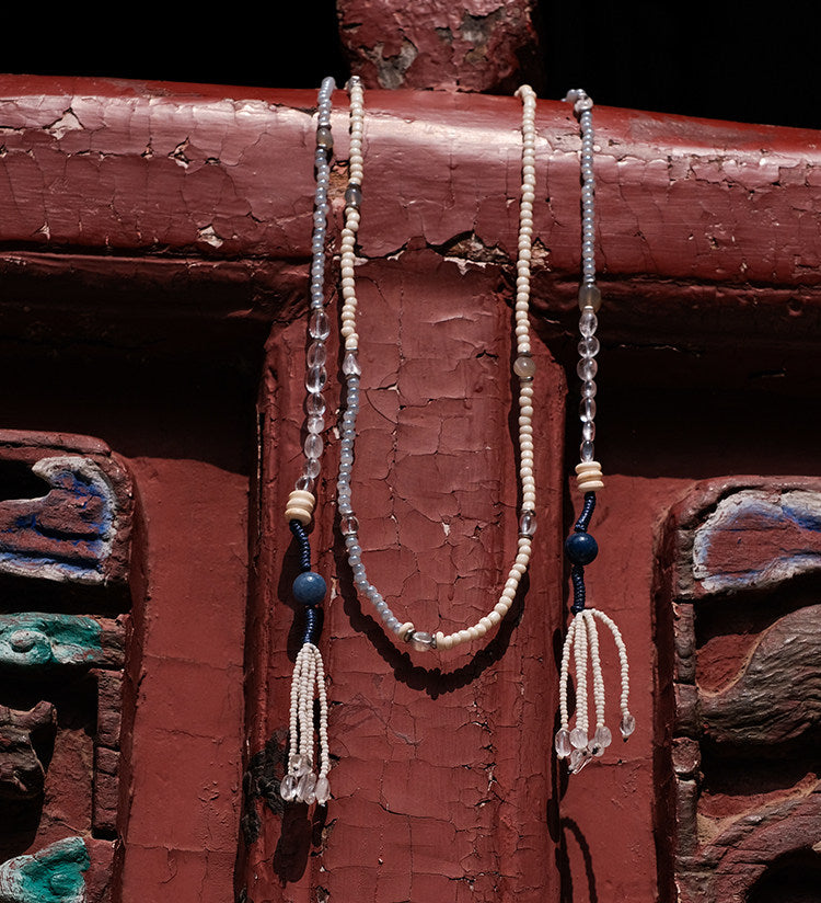 Clear Mind necklace flat lay showing full strand with all bead types and tassels