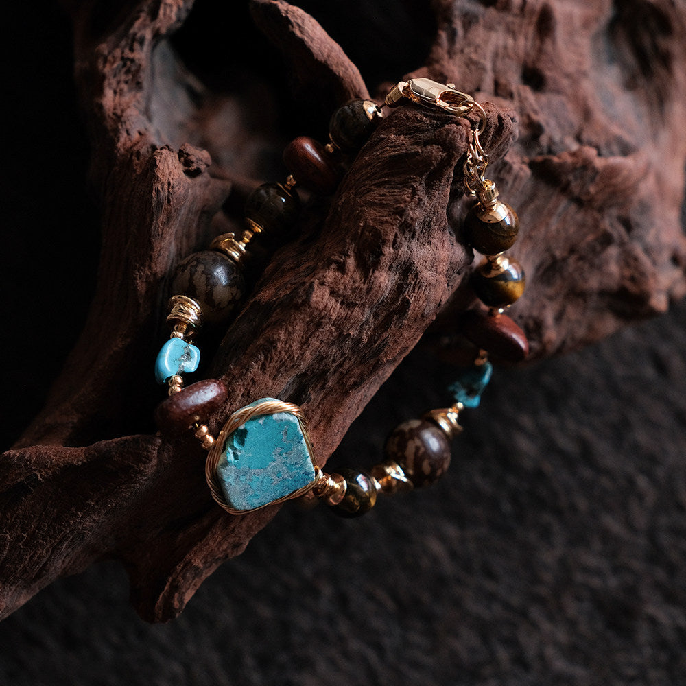 Moon Between Pines natural turquoise beaded bracelet draped over driftwood, front view