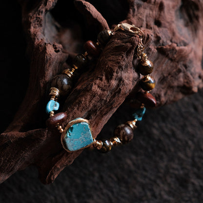 Moon Between Pines natural turquoise beaded bracelet draped over driftwood, front view