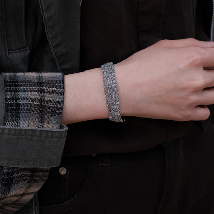 Between the Clouds handwoven crystal bracelet gold and silver variants with feather charms on moss, flat lay